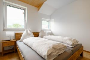 1 dormitorio con 2 camas y ventana en Ferienwohnung Schreierhof Bio Bauernhof, en Feldkirchen in Kärnten
