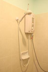 una doccia in bagno con spruzzatore su una parete di BT Mansion a Lamai Beach