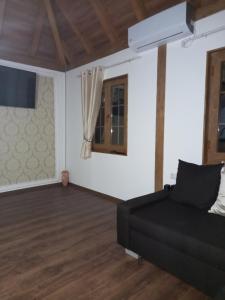 ein Wohnzimmer mit einem schwarzen Sofa und einem Fenster in der Unterkunft Natural Paradise in Bosanska Krupa