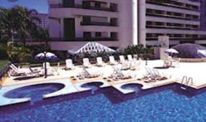 uma grande piscina com espreguiçadeiras e um edifício em Hotel Bonaparte Blue Residence F 209 em Brasília