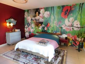 a bedroom with a bed with a painting on the wall at La Maison du Cerf in Urciers
