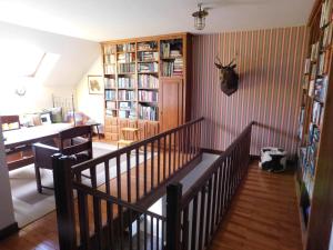 a living room with a staircase and a room with a desk at La Maison du Cerf in Urciers
