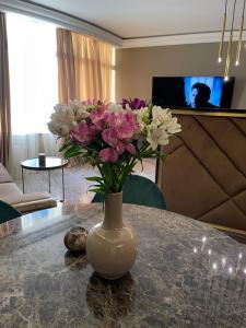 a vase filled with flowers sitting on a table at Apart Elena Arcadia Sea View in Odesa +29 photos