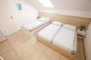 a small room with two beds and a bathroom at Rooms Klik in Postojna