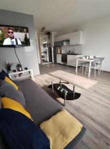 sala de estar con sofá y TV en la pared en Apartament FILO en Pogórze