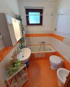 ein Badezimmer mit einem Waschbecken, einem WC und einer Badewanne in der Unterkunft La Finestra sul Conero Apartments in Numana
