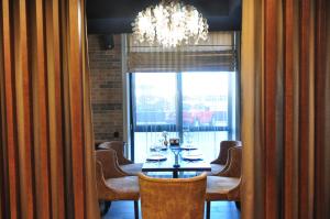 uma sala de jantar com uma mesa e cadeiras e um lustre em Light Hotel em Dnipro