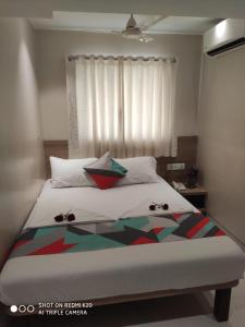 a bed with two pillows on it in a bedroom at Sai Sunder Guestline in Navi Mumbai