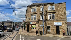 an old brick building on the corner of a street at William's Hillsborough Apartments in Sheffield