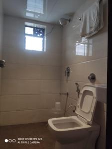 a small bathroom with a toilet and a window at Sai Sunder Guestline in Navi Mumbai