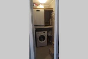 a room with a washing machine and a microwave at Cozy cottage close to idyllic archipelago with additional building if booked for more than 2 people in Eydehamn
