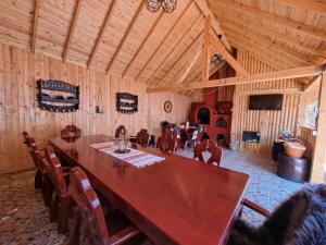 - une grande table en bois dans une pièce avec salle à manger dans l'établissement Casa Jeni, à Humuleşti