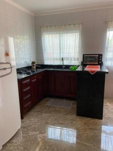 eine Küche mit einer schwarzen Arbeitsplatte und einem Kühlschrank in der Unterkunft Casa Charmosa in Paraty
