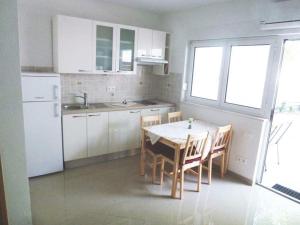 a kitchen with a table and chairs and a refrigerator at STUDIO APARTMENTS BaskaH2O in Baška Voda