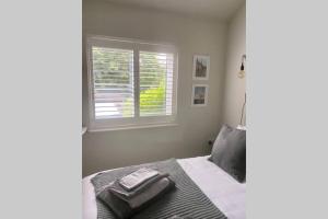 1 dormitorio con cama y ventana en Self contained annexe in the heart of Wedmore, en Wedmore