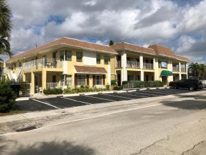 a yellow building with a car parked in front of it at Dee Jay Beach Resort in Fort Lauderdale