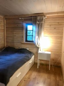 1 dormitorio con cama, mesa y ventana en Krodziņš Kristapiņš, en Babīte