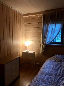 1 dormitorio con 1 cama y 1 mesa con lámpara en Krodziņš Kristapiņš en Babīte