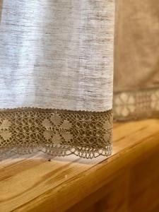 a beige and white curtain on top of a wooden table at Krodziņš Kristapiņš in Babīte