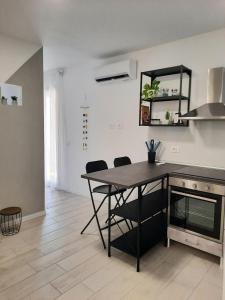una cucina con tavolo e sedie in una stanza di DAMASTE' CASA VACANZE PACHINO a Pachino