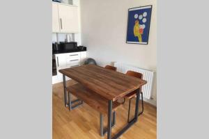 a kitchen with a wooden table in a room at Charming flat in Golders Green with parking space in London