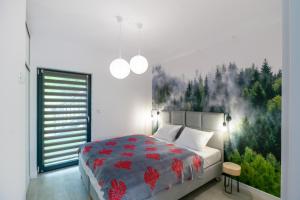 Schlafzimmer mit einem Bett mit Wandgemälde in der Unterkunft Szczyrkowskie SKI & FUN 8 z balkonem in Szczyrk