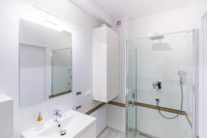 ein weißes Bad mit einer Dusche und einem Waschbecken in der Unterkunft Szczyrkowskie SKI & FUN 8 z balkonem in Szczyrk