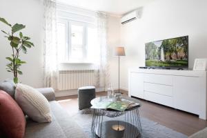 a living room with a couch and a tv at Sunny 2BDR Apartment with a Balcony in Zagreb
