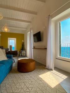 un soggiorno con divano blu e una grande finestra di La Ripa Camere Vernazza a Vernazza