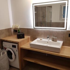 a bathroom with a sink and a washing machine at Rooftop-Schenna in Schenna +26 photos