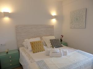 a bedroom with a white bed with two pillows on it at playamar in Torremolinos