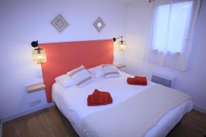 a bedroom with a large white bed with red pillows at Villa Mama Cocha 8 minutes à pied des plages in Sanary-sur-Mer