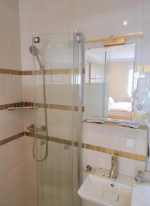 a bathroom with a shower and a sink and a mirror at Villa Natalia am See in Friedrichshafen