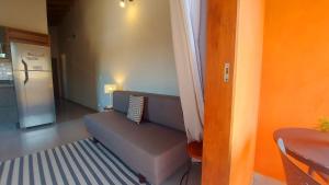 ein Wohnzimmer mit Couch und Kühlschrank in der Unterkunft Ventura - Apto com piscina, vista mar, churrasqueira privativa, ar con, wi-fi, netflix, garagem in Paraty + 14 Fotos