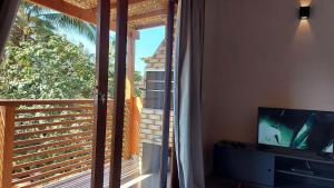 ein Wohnzimmer mit einem TV und einem großen Fenster in der Unterkunft Ventura - Apto com piscina, vista mar, churrasqueira privativa, ar con, wi-fi, netflix, garagem in Paraty