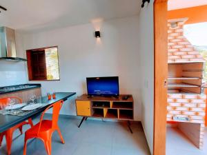 cocina con escritorio, TV y escalera en Cedro - Flat recém inaugurado, 50mts da Praia, Churr, Piscina, WiFi eficiente, Netflix, en Paraty
