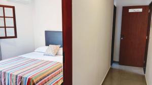 Un dormitorio con una cama y una puerta a una habitación. en Algodão - Novo Flat com Piscina, 50mts da praia, churrasqueira privativa, ar con, wi-fi, netflix, garagem, en Paraty 20 fotos más