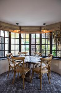 a dining room with a table and chairs and windows at Bay Horse Inn Goldsborough in Knaresborough