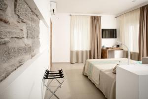 - une chambre avec un lit et une chaise dans l'établissement Assaje' Luxury Rooms, à Santa Teresa Gallura