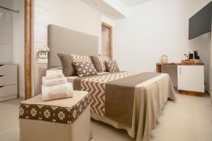 a bedroom with a bed with a table and a stool at Assaje' Luxury Rooms in Santa Teresa Gallura