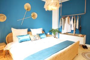 a bedroom with a blue wall and a bed with pillows at SECRET HIDEAWAYS tropical Feeling mit 2 Schlafzimmer nahe City l Messe l Flughafen l Hbf in Duisburg