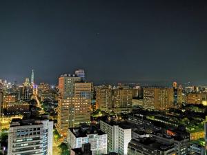 a city skyline at night with tall buildings at urban abode apartments in Taipei