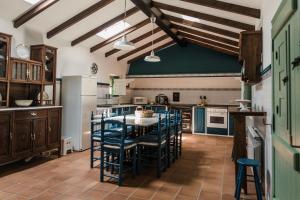 a kitchen with a table and some blue chairs at Saramagoso in Meis