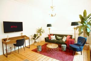 a living room with a couch and a tv at SECRET HIDEAWAYS tropical Feeling mit 2 Schlafzimmer nahe City l Messe l Flughafen l Hbf in Duisburg
