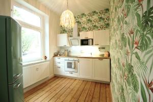 a kitchen with white cabinets and a window at SECRET HIDEAWAYS tropical Feeling mit 2 Schlafzimmer nahe City l Messe l Flughafen l Hbf in Duisburg