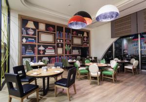 a restaurant with tables and chairs and books at Titanic Deluxe Lara in Lara