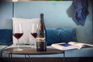 a bottle of wine sitting on a table with two glasses at VistaLago Torbole in Nago-Torbole