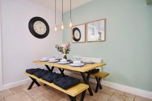 comedor con mesa, sillas y reloj en Wonderful Apartment in Bath wGarden - Sleeps 8 en Bath