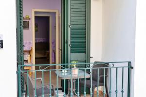 un tavolo e sedie su un balcone con porta verde di La Torretta Dei Sogni a Corsano