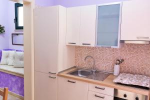 a kitchen with white cabinets and a sink at La Torretta Dei Sogni in Corsano